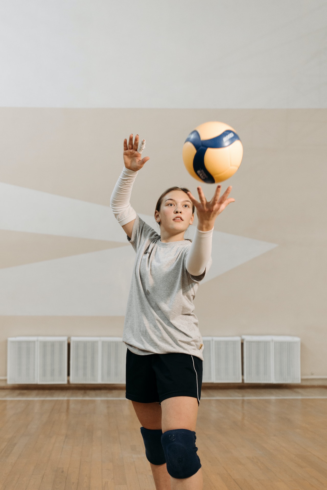 young girl serving volleyball